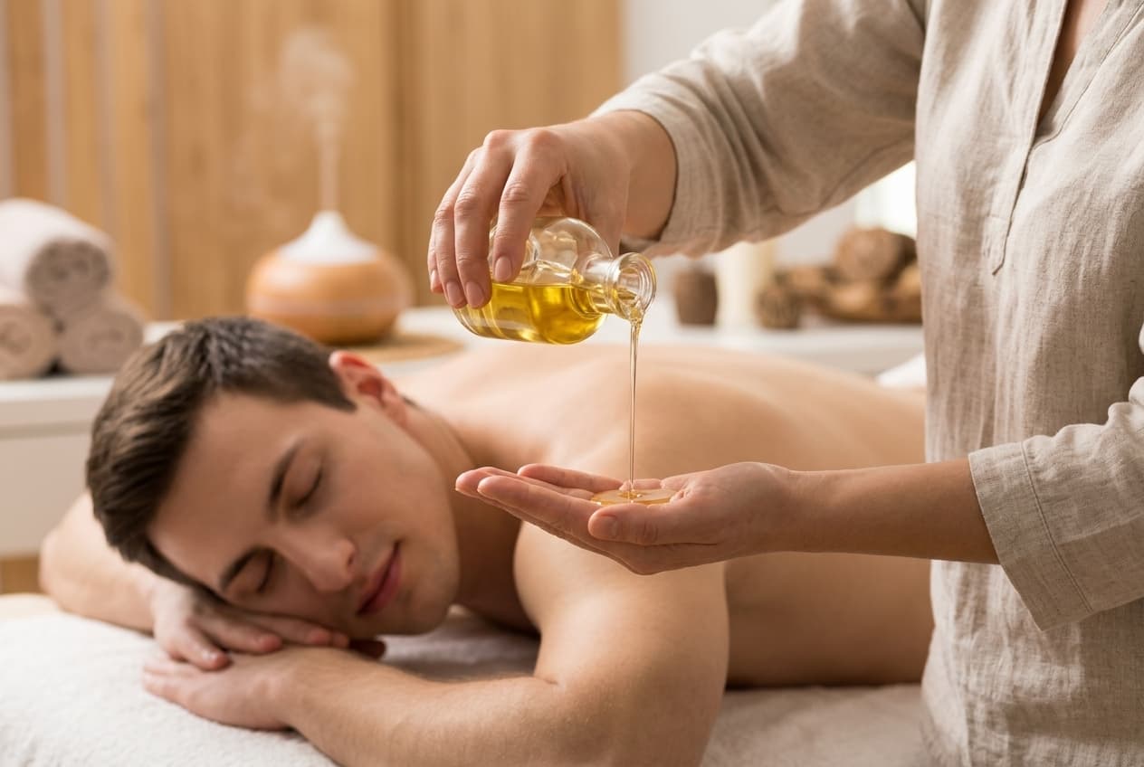 Therapist pouring warm massage oil in quiet relaxing space