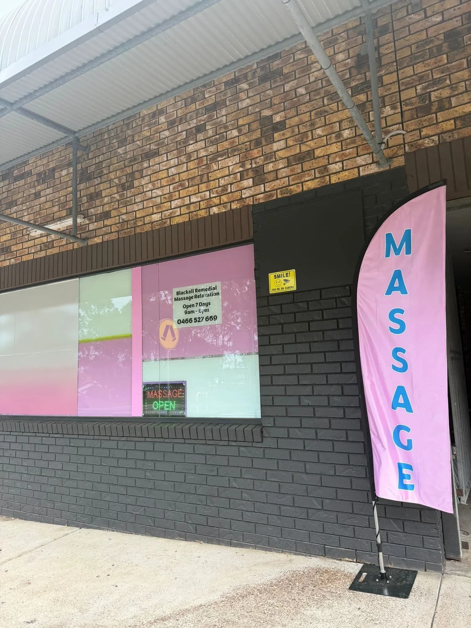 Blackall Remedial Massage storefront with pink massage flag banner and neon open sign